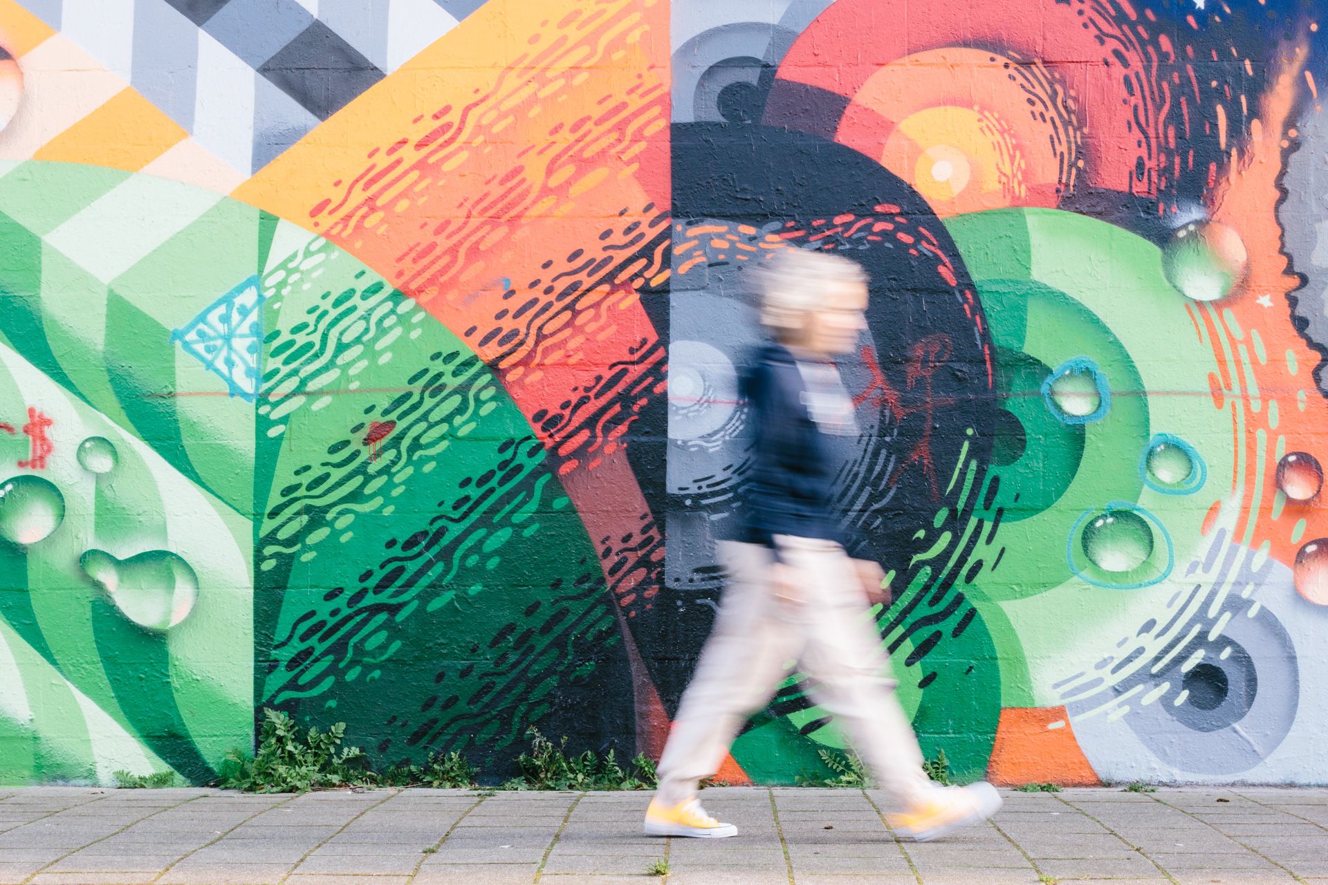 Bewegend beeld van Noëlla die langs een graffitimuur loopt